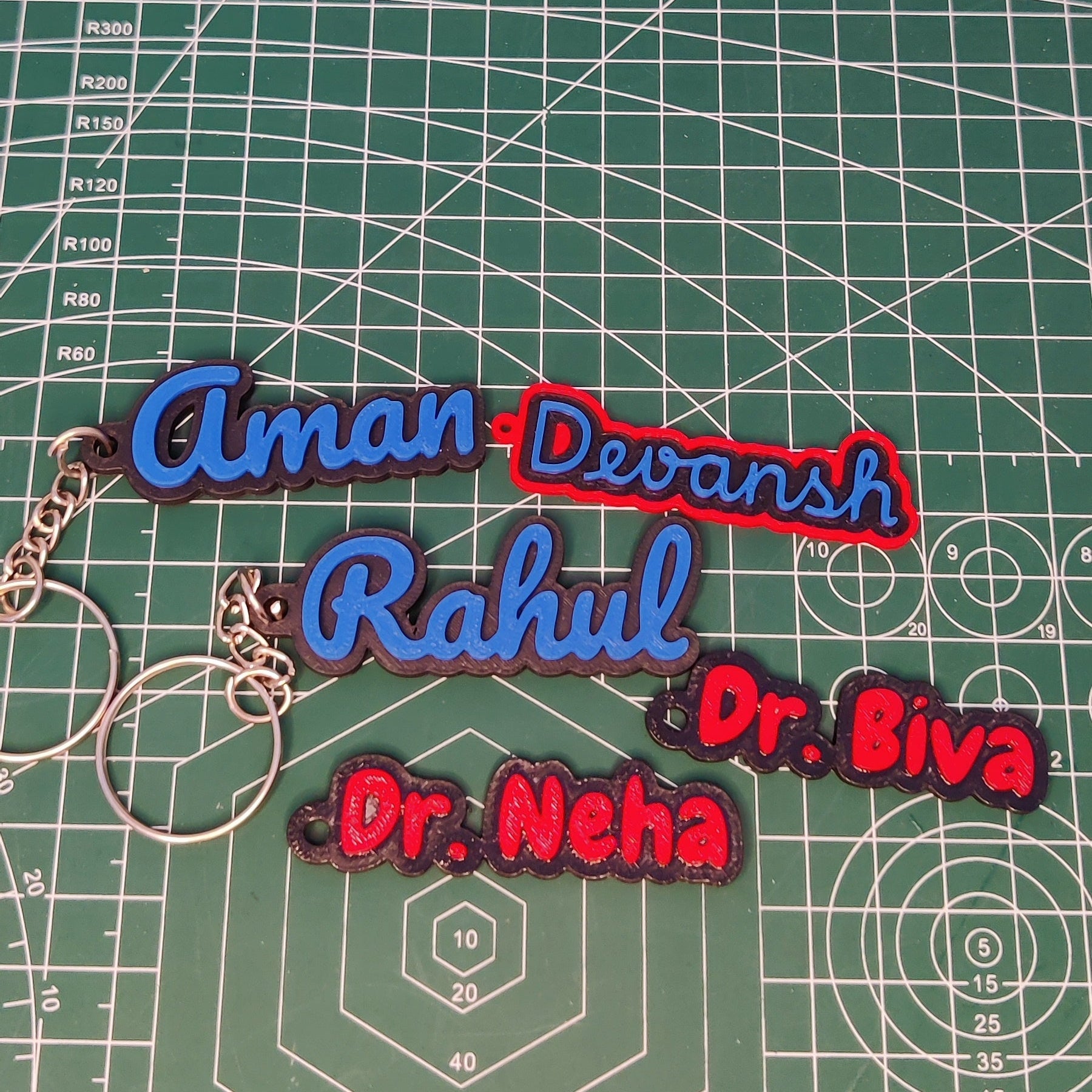 Colorful keychains with names on a green cutting mat